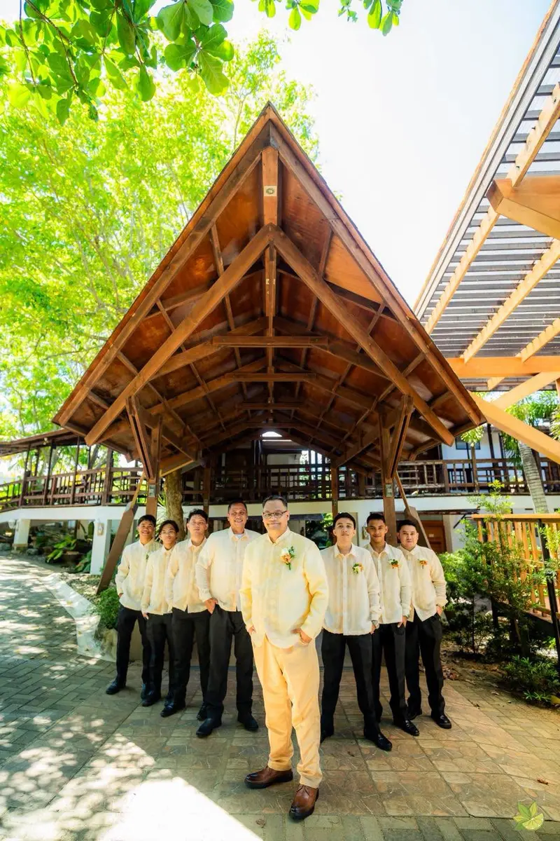 Groomsmen in yellow and black at a garden venue